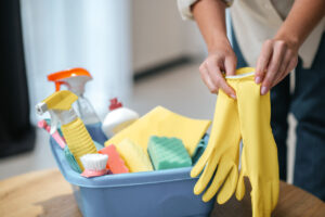 Primer plano de manos femeninas usando guantes de limpieza amarillos