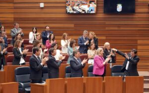 Mañueco y otros asistentes aplaudiendo en un evento político.