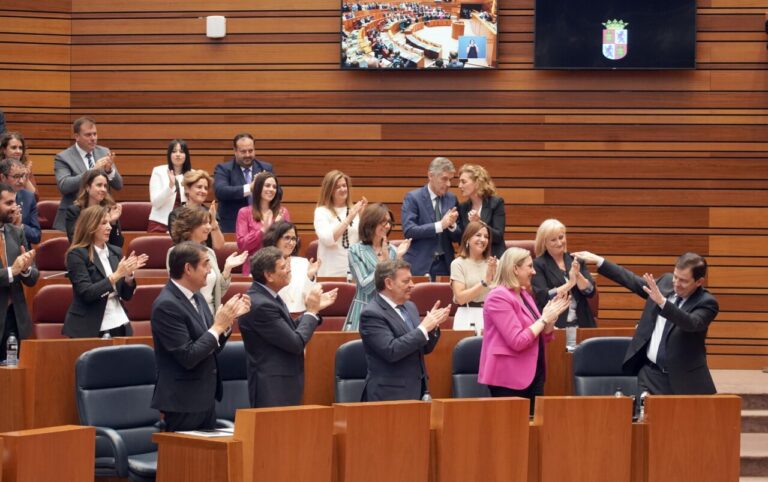 Mañueco y otros asistentes aplaudiendo en un evento político.