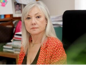 Retrato de María José Ortega en su oficina, con fondo de documentos.