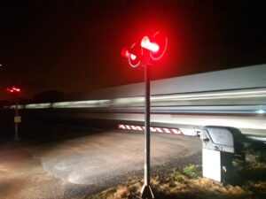 Señalización de paso a nivel con luces rojas en la noche