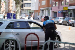 Un policía revisando un vehículo en Palencia mientras se alerta sobre estafas de multas