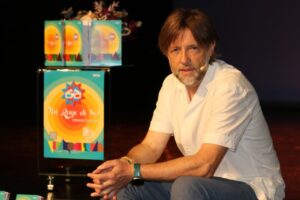 Presentador en evento cultural de Palencia con cartel de verano.