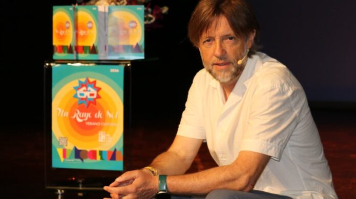 Presentador en evento cultural de Palencia con cartel de verano.