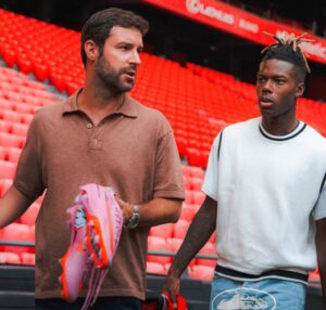 Pablo Ramos conversando con un deportista en un estadio