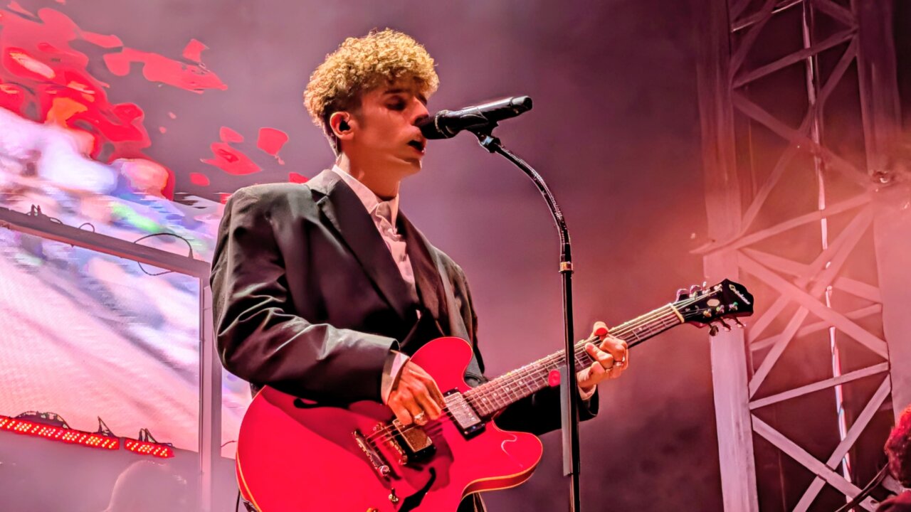 Músico de la banda Veintiuno tocando la guitarra en el festival Palencia Sonora