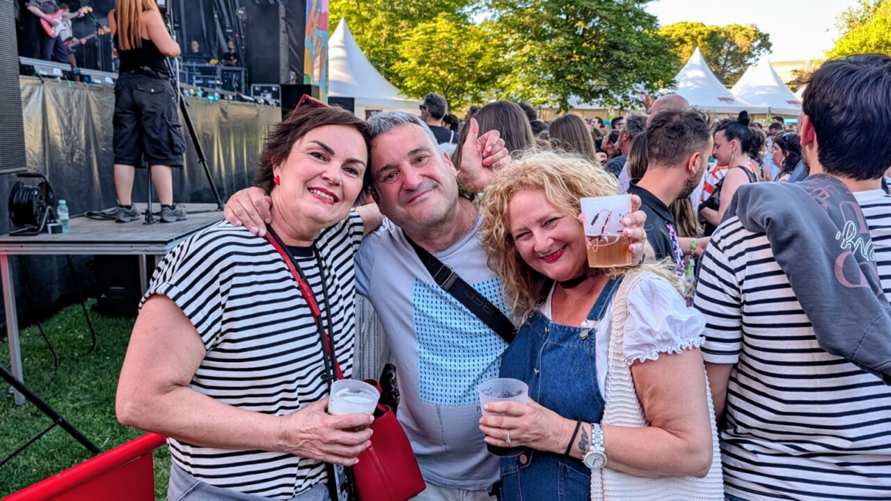 Tres personas sonriendo en el festival Palencia Sonora con bebidas