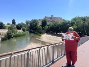 Turista leyendo un mapa en Peñafiel junto al río y castillo