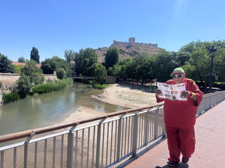 Turista leyendo un mapa en Peñafiel junto al río y castillo