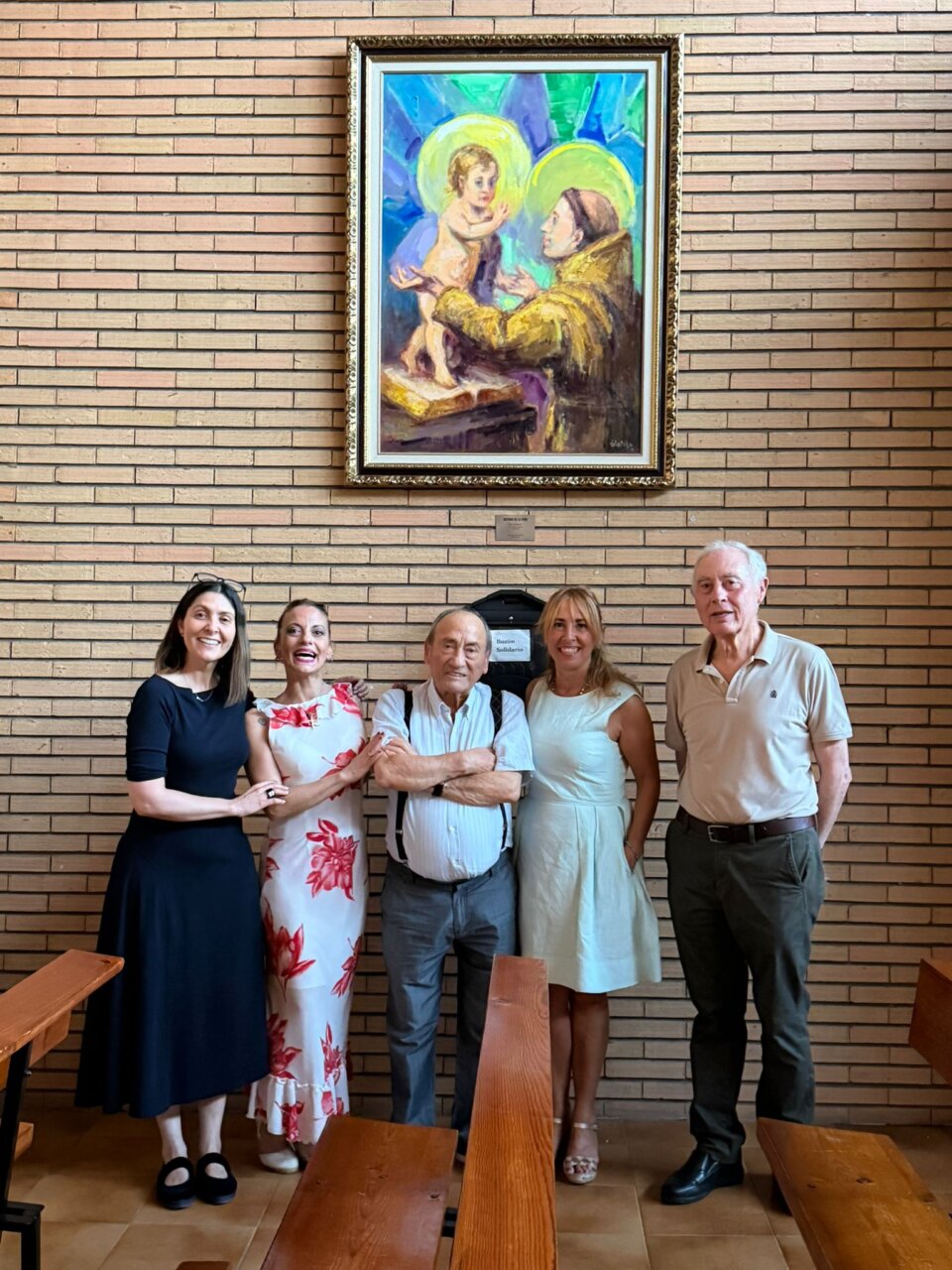 Grupo de personas junto a la pintura San Antonio y el Niño Jesús