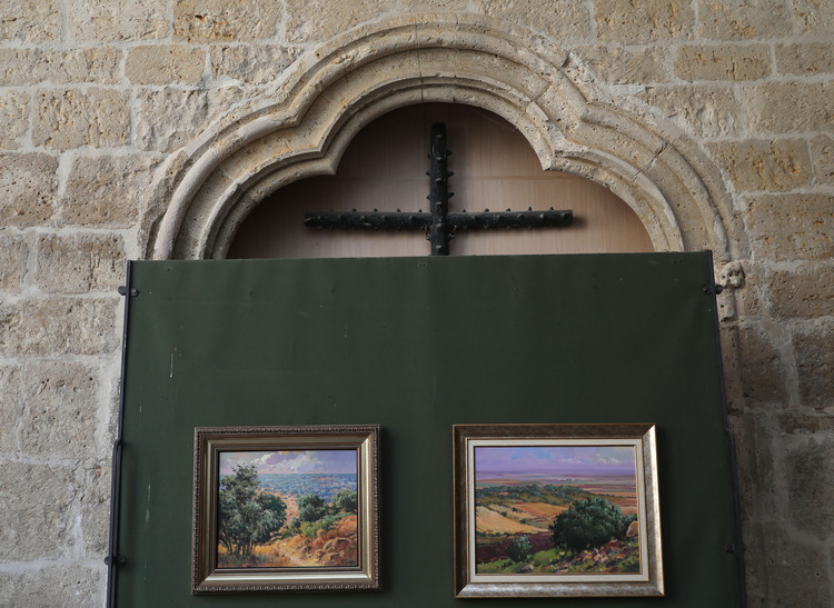 Puerta con cuadros en una pared de piedra con cruz