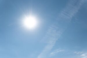 Rayos de sol brillando en un cielo azul con nubes