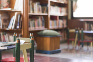 Mesa y sillas para niños en una biblioteca con estanterías de libros