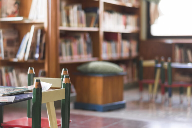 Mesa y sillas para niños en una biblioteca con estanterías de libros