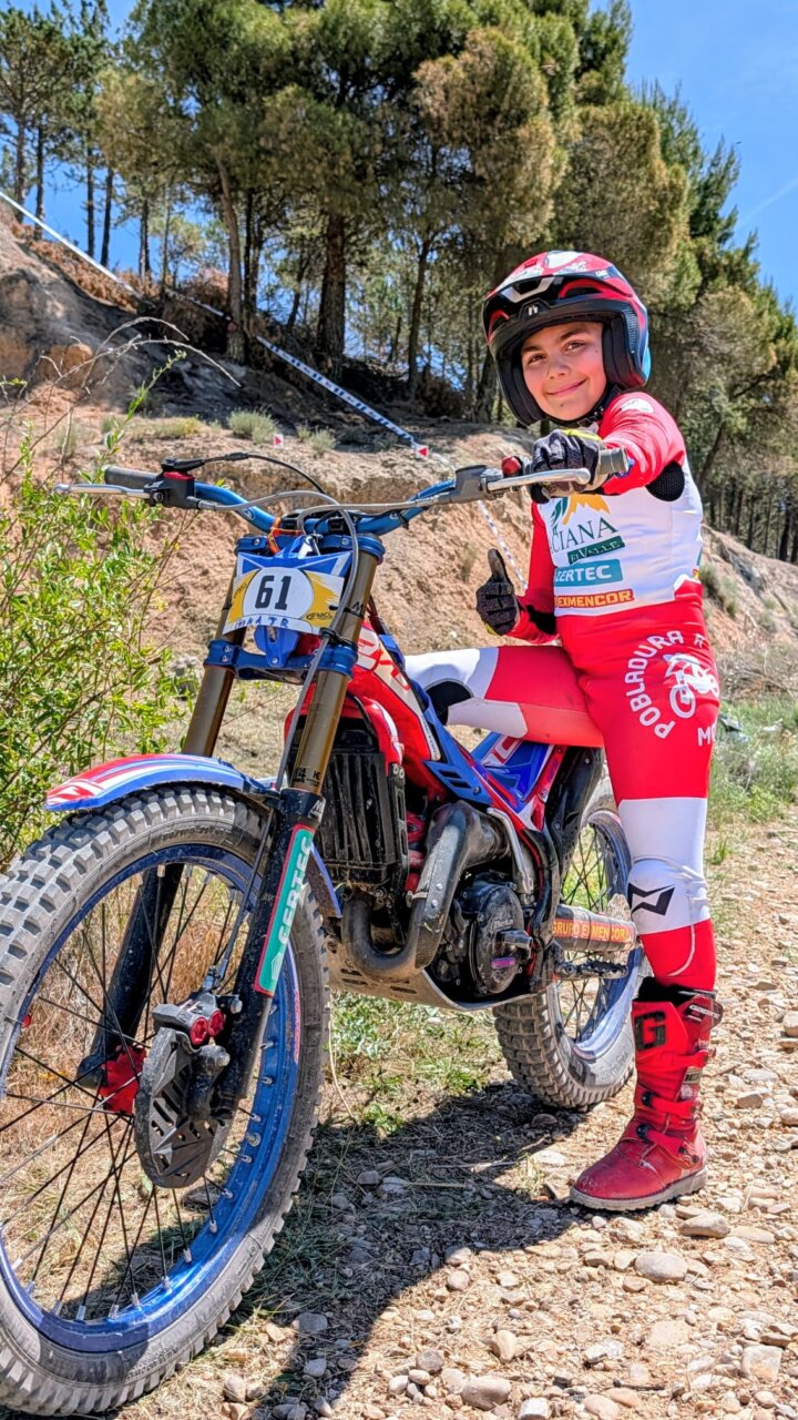 Joven piloto de trial sonriendo mientras sostiene su moto en Tabanera de Cerrato