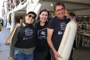 Tres personas sonrientes en un evento de cerámica en Palencia
