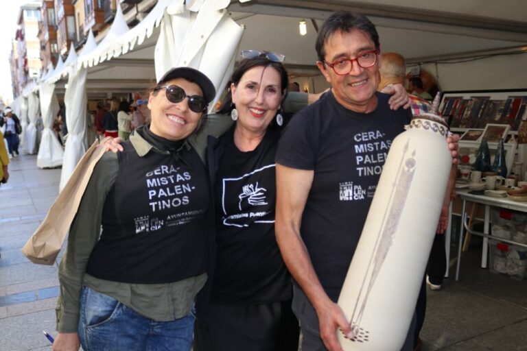 Tres personas sonrientes en un evento de cerámica en Palencia