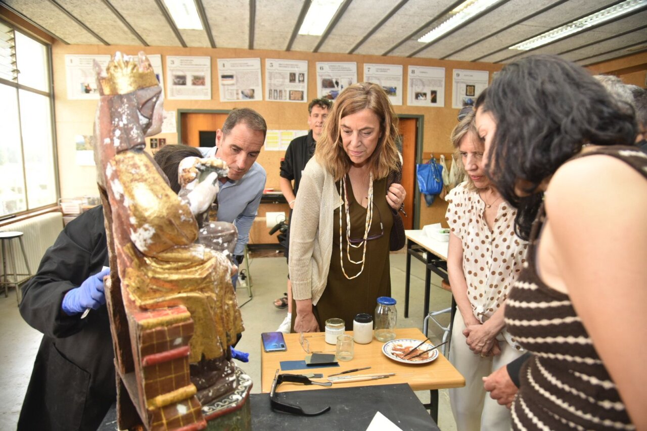 Grupo de restauradores trabajando en una escultura en un taller de arte