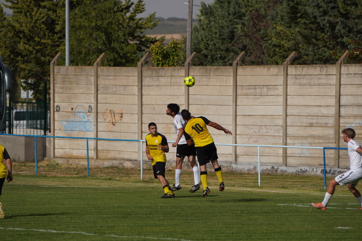 Jugadores de fútbol en un salto durante el partido entre San Cebrián y Torquemada