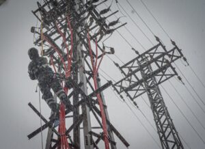 Técnico trabajando en una torre eléctrica durante una tormenta