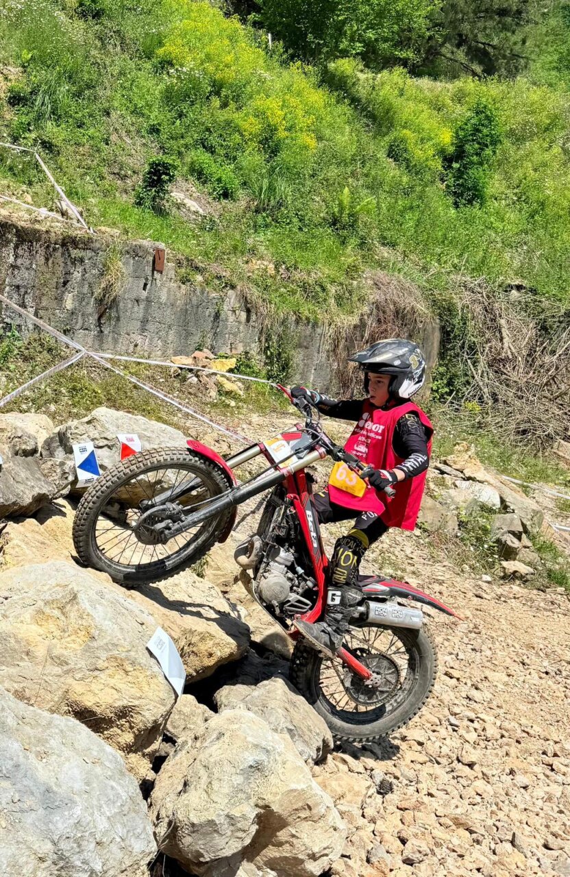 Joven piloto de trial superando obstáculos en una competición