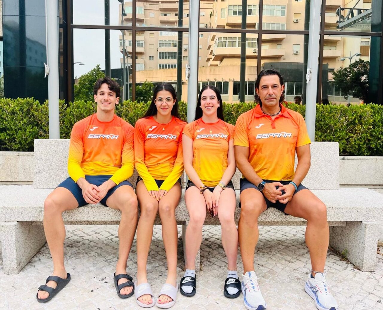 Cuatro atletas españoles posando en Lisboa con camisetas de España