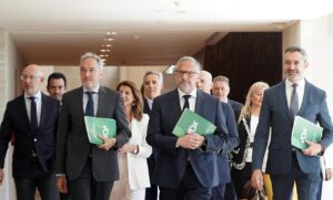 Grupo de representantes de Vox caminando con documentos en mano.