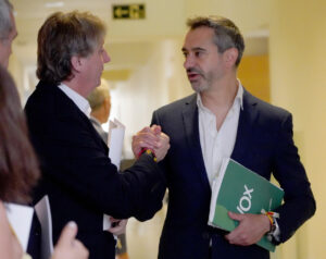 Dos hombres estrechándose la mano en un entorno formal.
