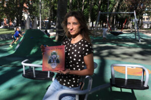 Mujer sosteniendo el libro Antón aliento de dragón en un parque