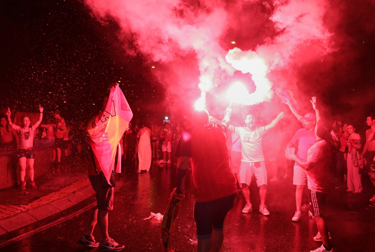 Aficionados celebrando la victoria de España en el Mundial con bengalas y banderas