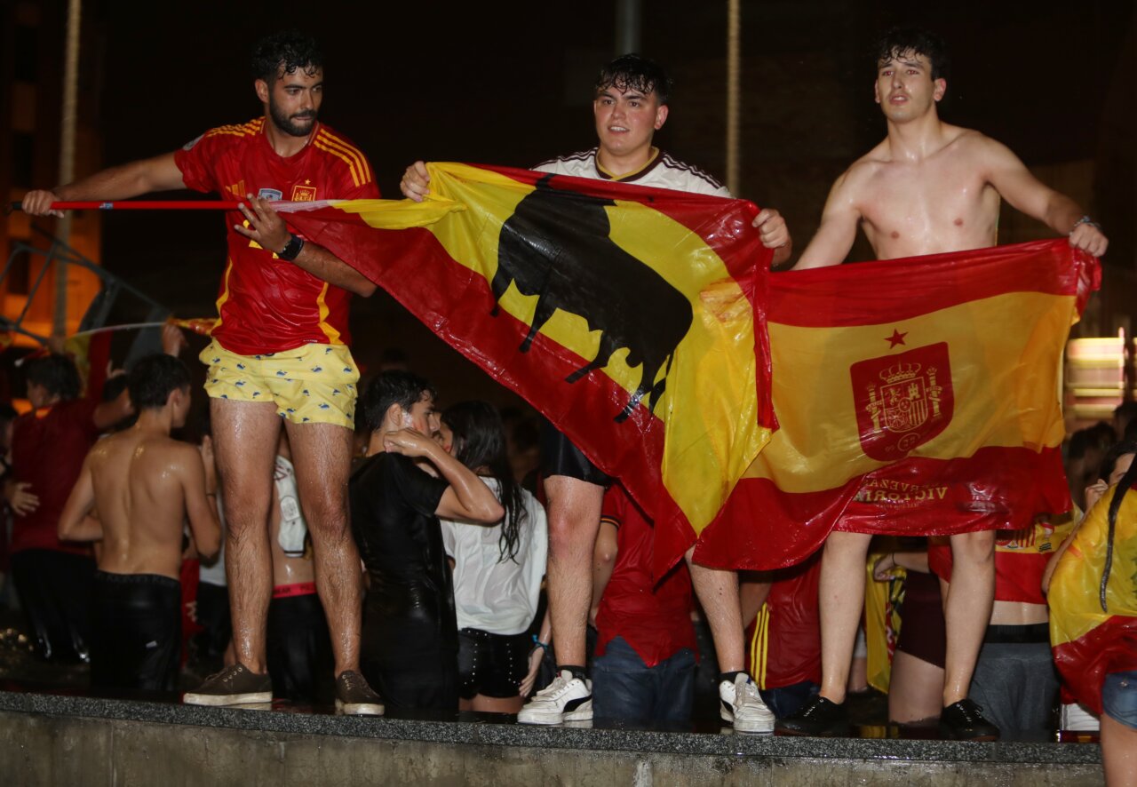 Jóvenes celebrando la victoria de España con banderas en la Plaza España