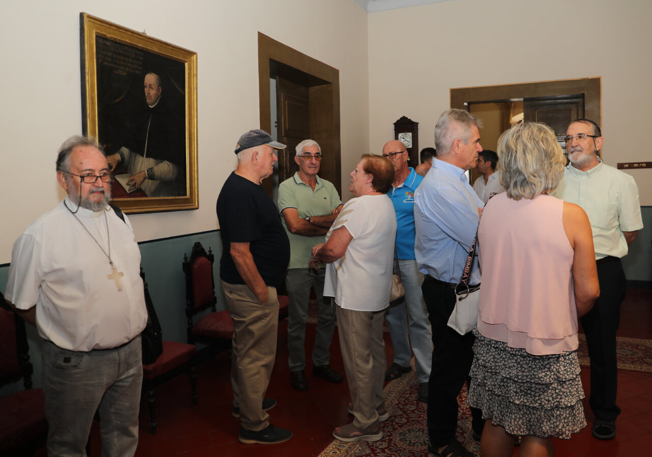 Reunión de misioneros en el Obispado de Palencia con un retrato en la pared.