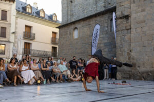 Un bailarín realizando un movimiento acrobático en un festival de danza.