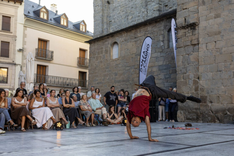 Un bailarín realizando un movimiento acrobático en un festival de danza.