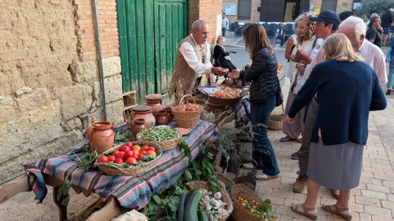 Vecinos de Husillos interactuando en un mercado medieval recreado