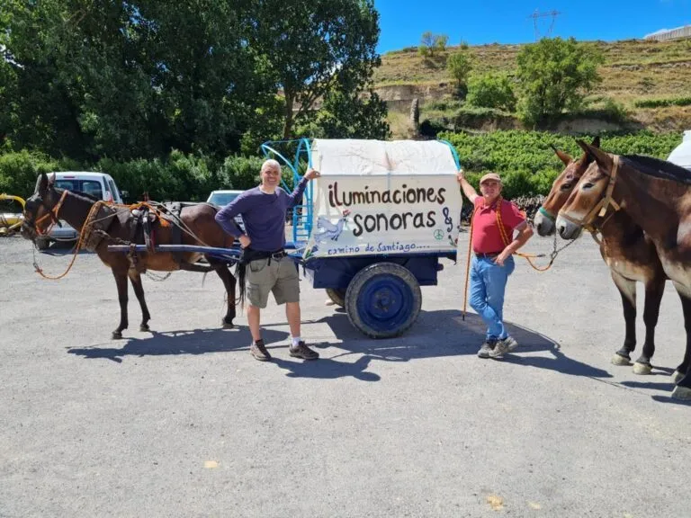 Dos hombres junto a una mula y un carro con el texto iluminaciones sonoras