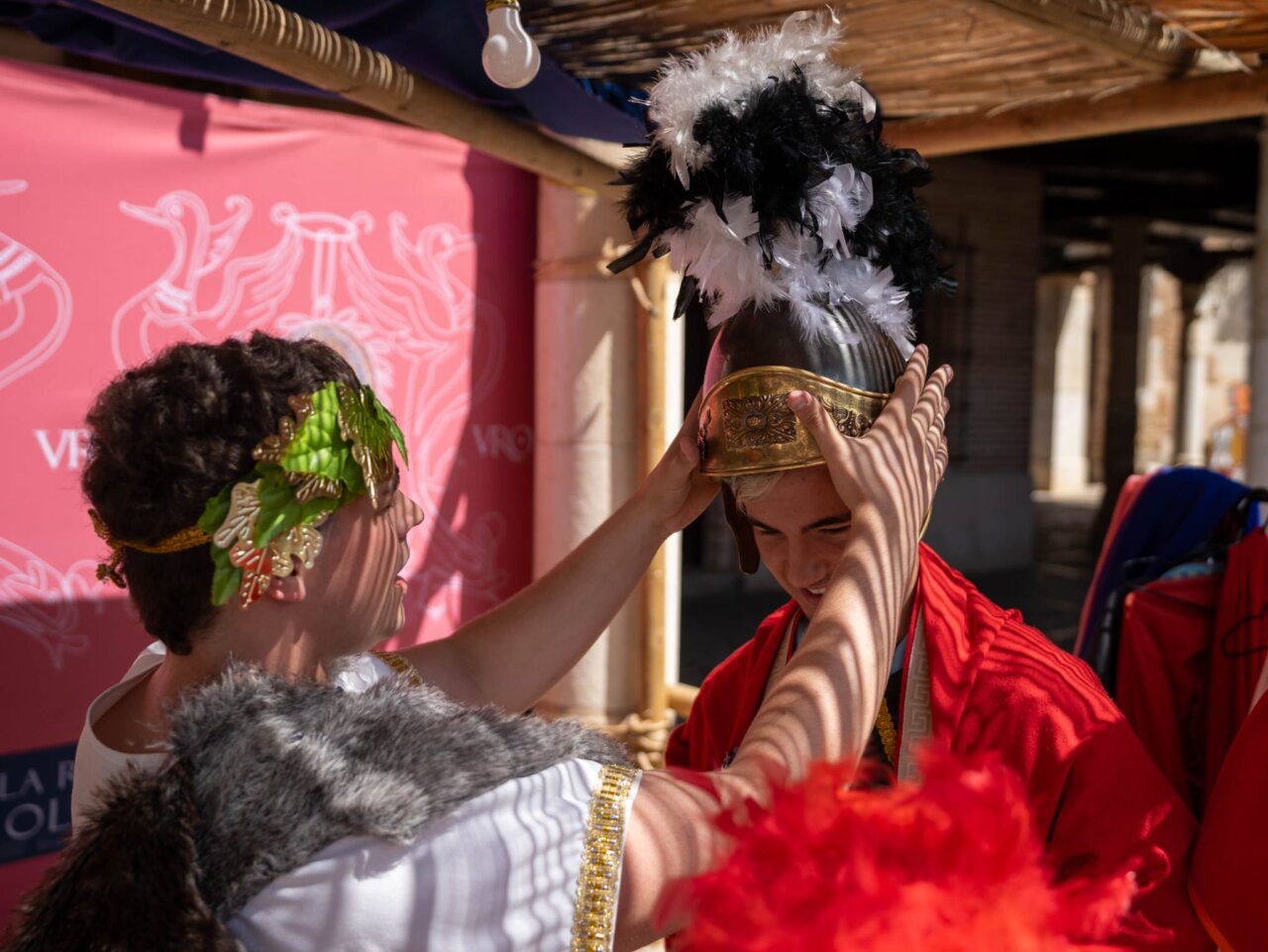 Dos personas visten trajes romanos en el Mercado Romano de Saldaña.
