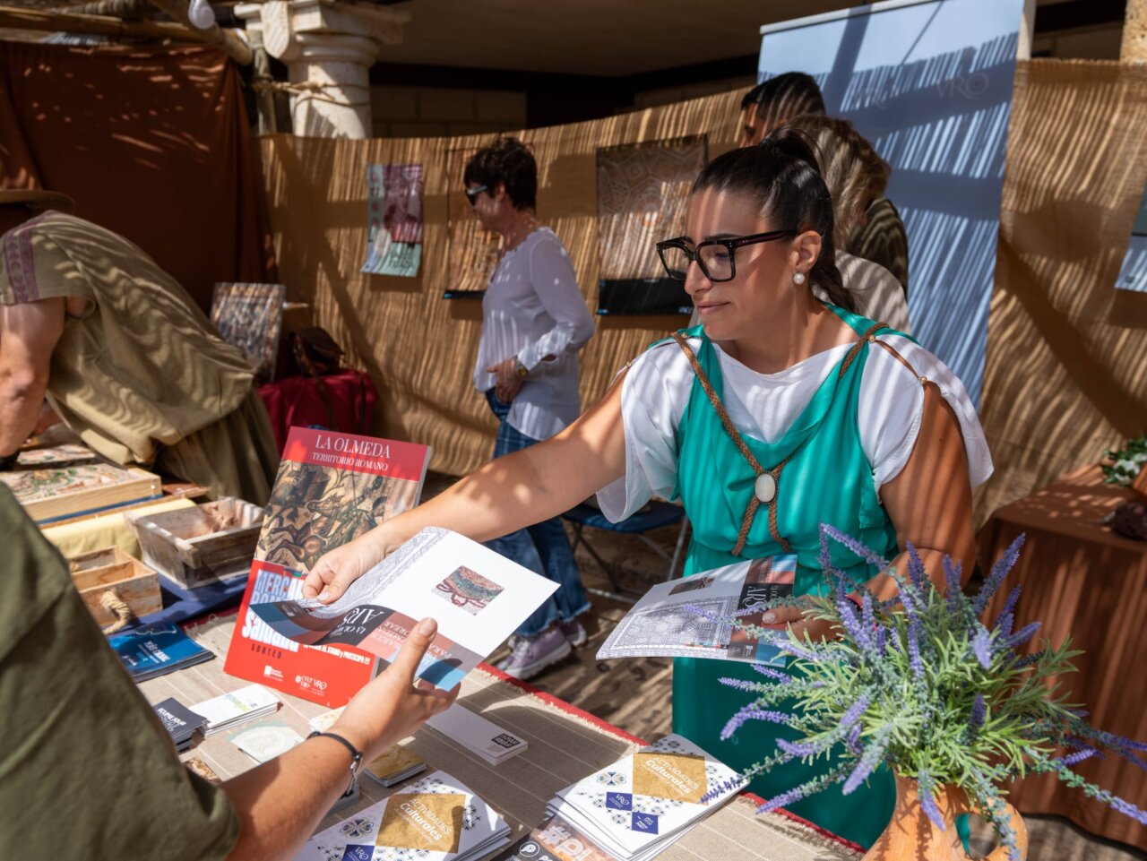 Persona en vestimenta romana interactuando en un mercado histórico