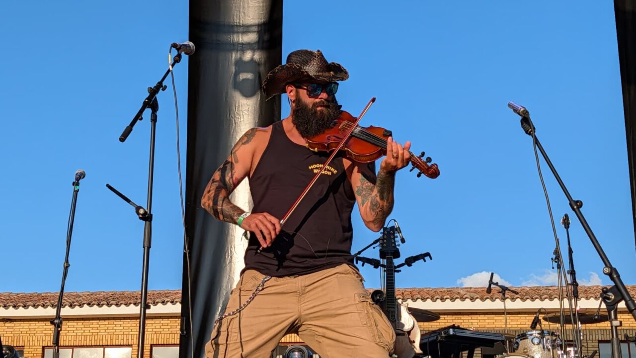 Músico de Moonshine Wagon tocando el violín en el festival PipaFest