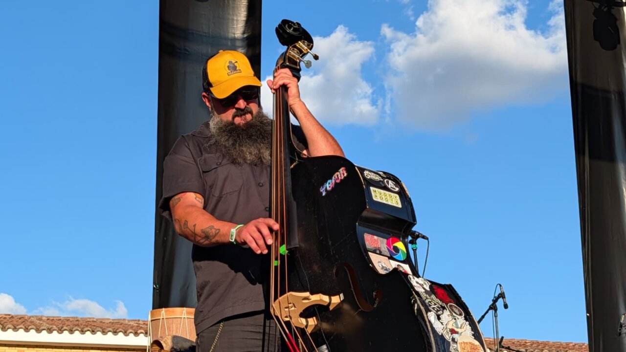Músico de la banda Moonshine Wagon tocando el contrabajo en el PipaFest