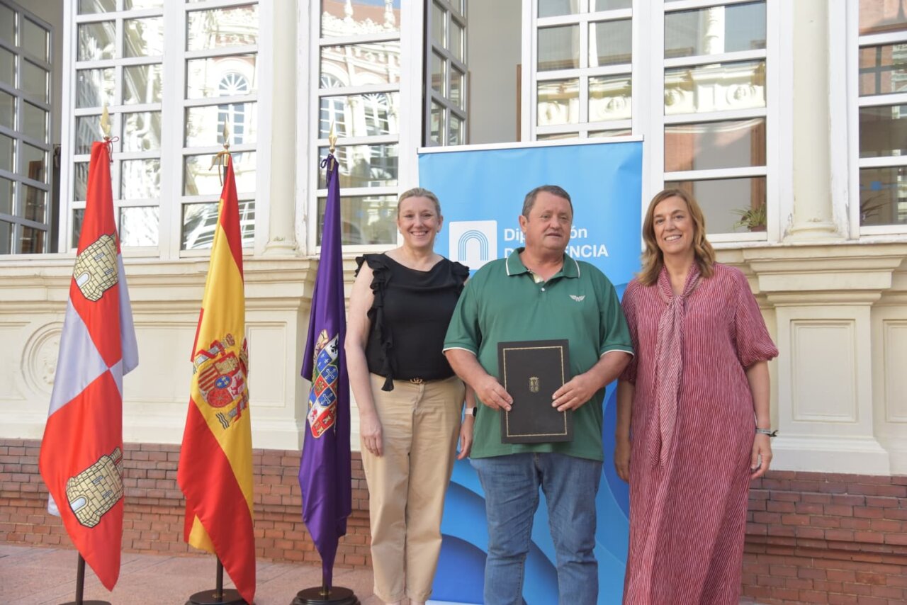 Tres personas posando frente a un banner del programa Rehabitare en Palencia.