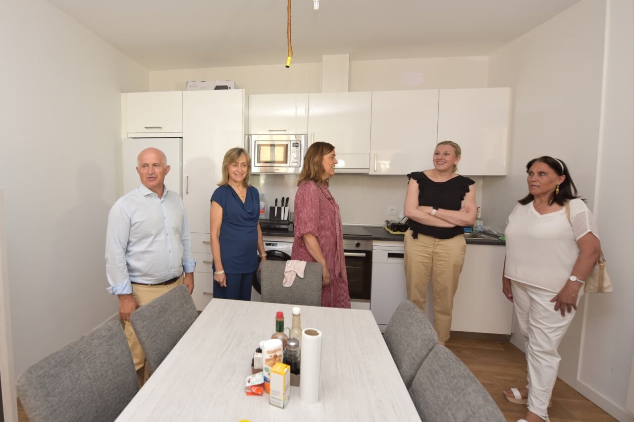 Grupo de personas en una cocina moderna tras la rehabilitación de una vivienda