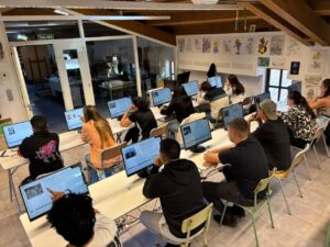 Estudiantes realizando exámenes teóricos de tráfico en computadoras.