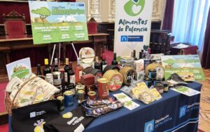 Mesa con productos de Alimentos de Palencia y cartel de muestras alimentarias
