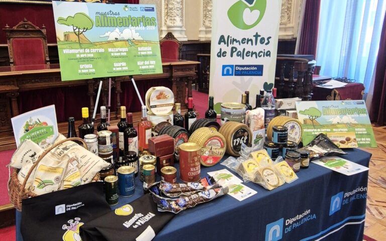 Mesa con productos de Alimentos de Palencia y cartel de muestras alimentarias