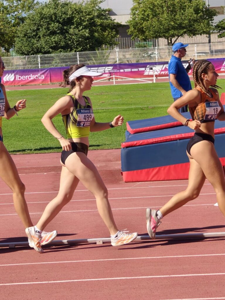Tres atletas compitiendo en una carrera de atletismo en una pista