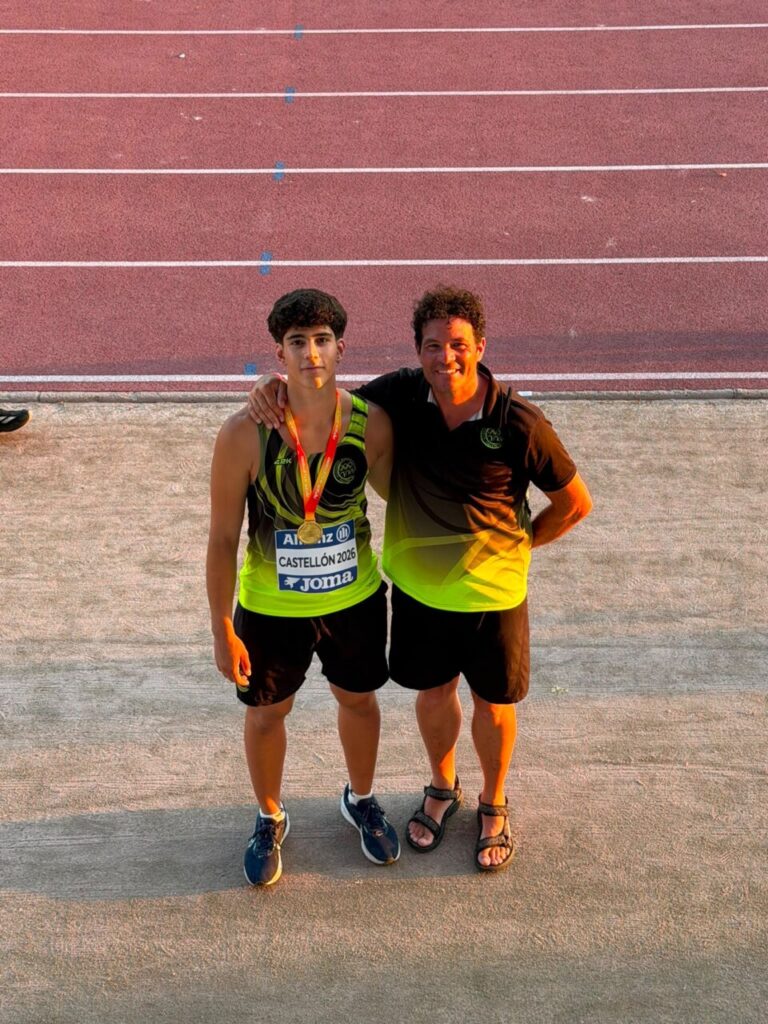 Dos atletas posando en la pista de atletismo con medallas