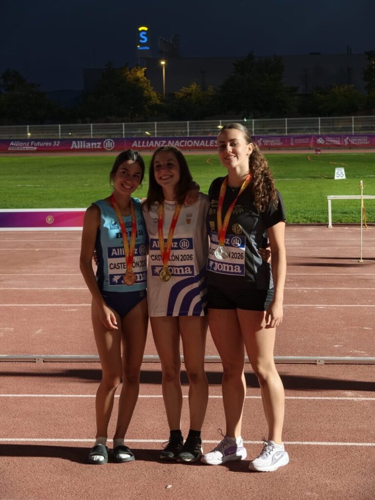 Tres atletas posando con medallas en un evento deportivo