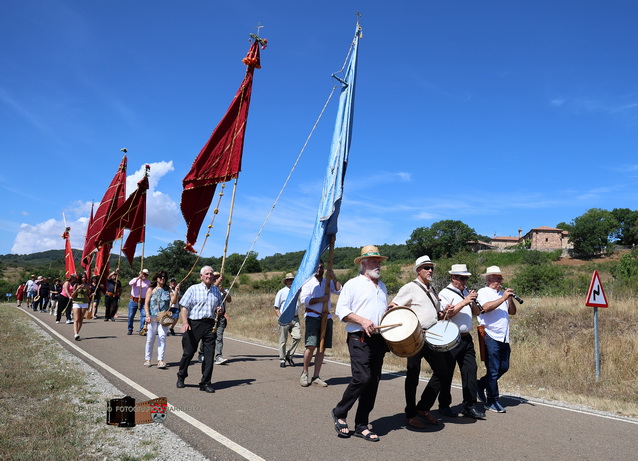 Grupo de personas en romería con banderas en Barruelo