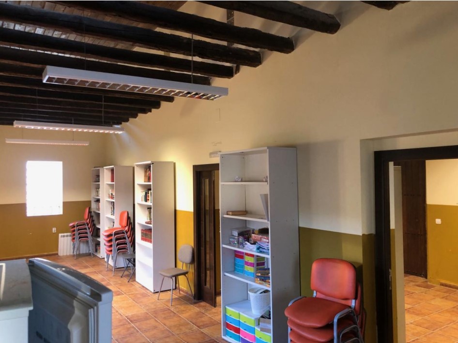 Interior de la antigua biblioteca en Quintana del Puente con estanterías y sillas